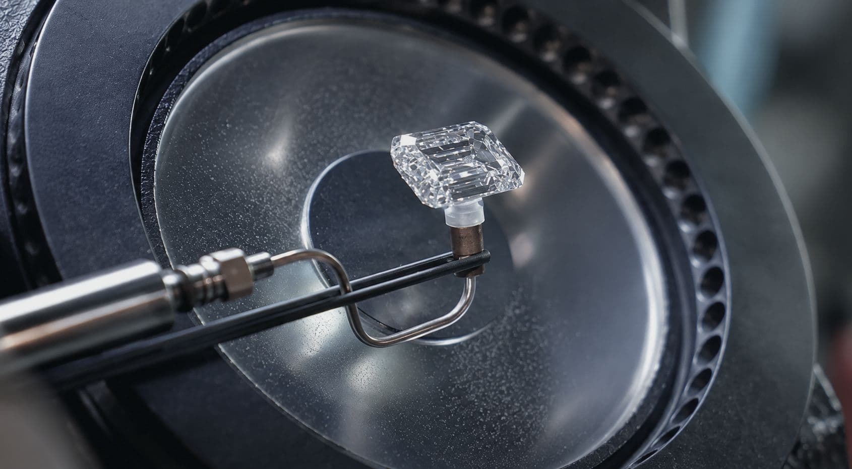 Polished emerald-cut diamond being examined with precision equipment